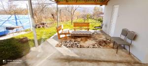 eine Terrasse mit 2 Stühlen, einem Tisch und einer Bank in der Unterkunft Beloved Home in Çilǝgir