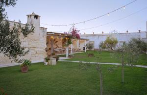a courtyard of a building with a yard with trees at Masseria Rauccio in Torre dell'Orso +134 photos