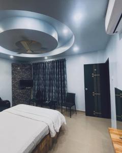 PanhālaNatural resort的一间卧室，里面有一张白色床，天花板上有一个房间 更多1张照片