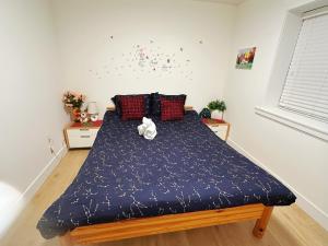 un letto con un orsacchiotto in una camera da letto di Cozy Dreamscape a Surrey