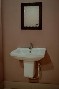 Fine Homes في كالباتّا: حمام مع حوض وصورة على الحائط