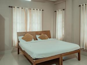 Fine Homes في كالباتّا: غرفة نوم مع سرير مع ملاءات بيضاء ووسائد بنية