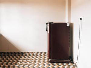 Fine Homes في كالباتّا: حقيبة بنية اللون موضوعة في غرفة بها جدار