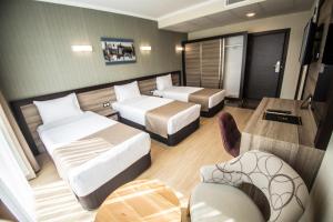 ein Hotelzimmer mit zwei Betten und einer Couch in der Unterkunft The Corner Hotel in Sincan