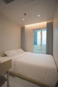 una camera da letto con un grande letto bianco e una finestra di Stay Hello Hongdae Sinchon a Seul