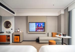 a living room with a tv on the wall at FunGee X Hotel Wanzhou Wanda Plaza Branch in Wanzhou