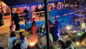 a group of people sitting around a fire at a party at Mountain Harbour B&B in Roan Mountain