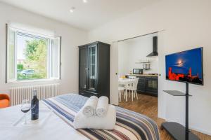 a room with a bed and a tv and a kitchen at La Coroncina Lodging in Siena