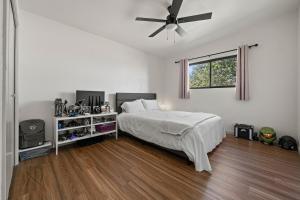 NEW Cozy Central l 4 BDRM 2BTH l 1 acre LOT في سييرا فيستا: غرفة نوم بها سرير ومروحة سقف