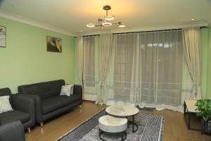 un soggiorno con un divano e un tavolo di Mercella Homes - Munyonyo a Kampala