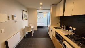 a kitchen with a sink and a stove top oven at One Bedroom Penthouse Apartment in the heart of Box Hill in Box Hill