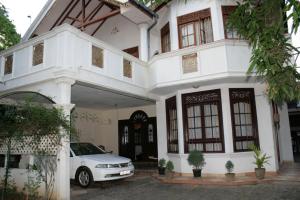 un coche blanco estacionado frente a una casa blanca en Martin Villa, en Matara