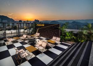a rooftop patio with chairs and a table on a building at FunGee X Hotel Wanzhou Wanda Plaza Branch in Wanzhou