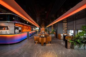 a restaurant with tables and chairs and a bar at FunGee X Hotel Wanzhou Wanda Plaza Branch in Wanzhou