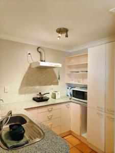 a kitchen with a sink and a counter top at Bayview Holiday Flat in Auckland