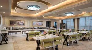 um restaurante com mesas e cadeiras em uma sala em Vienna Hotel Guangdong Foshan Lishui 1st City em Lishui
