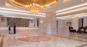 um grande saguão com um lustre e pessoas em pé nele em Vienna Hotel Guangdong Foshan Lishui 1st City em Lishui
