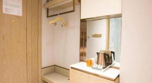 济南Vienna Hotel Jinan Beiyuan Street Red Star Macalline的厨房配有带咖啡机的柜台