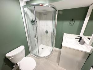 a bathroom with a shower and a toilet and a sink at Bright & Spacious House Near UBC in Vancouver +40 photos
