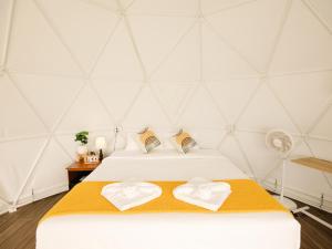 una stanza con un letto con due asciugamani sopra di L1 Lanta Resort a Ko Lanta