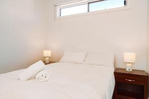 ein Schlafzimmer mit einem weißen Bett mit zwei Lampen in der Unterkunft Eden Bay Mornington in Capel Sound