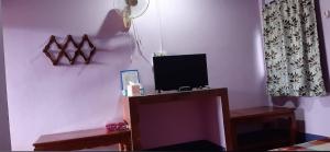 a living room with a tv on a wall at Saran Resort room 11 in Buriram