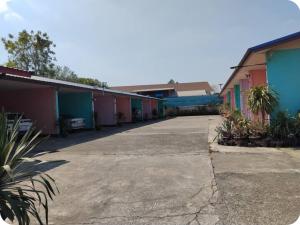 a row of colorful buildings in a parking lot at Saran Resort room 11 in Buriram