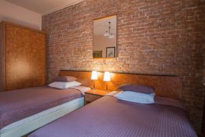 a bedroom with two beds and a brick wall at Finger Guest Rooms in Krakow