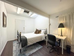 a bedroom with a bed and a desk and a chair at Bright & Spacious House Near UBC in Vancouver