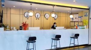 a woman wearing a mask behind a counter in a restaurant at GreenTree Inn Express Jinan Zhangqiu Districty Ancinet Town Longquan Road in Zhangqiu