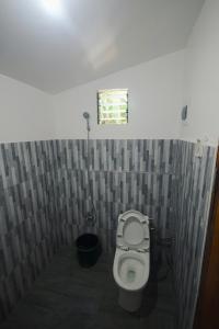 ein Badezimmer mit Toilette und kleinem Fenster in der Unterkunft Verde Bungalows Siargao in General Luna
