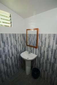 ein Badezimmer mit Waschbecken und Spiegel in der Unterkunft Verde Bungalows Siargao in General Luna + 50 Fotos