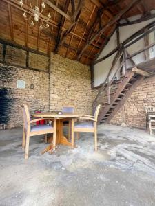 a wooden table with two chairs and a laptop on it at Онгъл Харман in Kŭrpachevo +17 photos