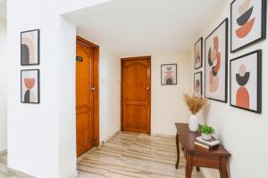 a hallway with a wooden door and a table at FabHotel Rest & Peace in Ahmedabad