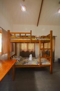 2 Etagenbetten in einem Zimmer mit einem Tisch in der Unterkunft Verde Bungalows Siargao in General Luna