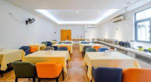 Vienna Hotel Shenzhen Guanlan Shanshuitianyuan Xintian في Tiantangwei: غرفة طعام مع طاولات وكراسي وكافتريا