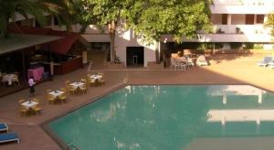uma vista aérea de uma piscina com mesas e cadeiras em Pailyn Hotel em Sukhothai