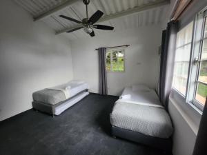 a bedroom with two beds and a ceiling fan at Hotel San Pedro de Taboga in Taboga +28 photos