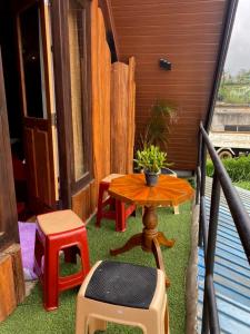努沃勒埃利耶The Heaven Wood Cabin的阳台上摆着一张小桌子和一张凳子。