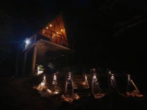 een huis 's nachts met een vuur ervoor bij Pinna Eco in Galle +8 foto's