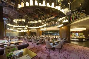 uma sala de jantar com mesas e cadeiras em um restaurante em DongGuan JOYC Hotel  em Dongguan