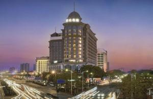 um edifício alto com uma torre de relógio em cima em DongGuan JOYC Hotel  em Dongguan