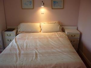 a small bedroom with a bed and two night stands at Ardmore House in Kenmare