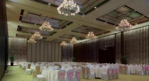 Un salón de banquetes con mesas y sillas blancas y candelabros. en Eadry Royal Garden Hotel Haikou, en Haikou 273 fotos más