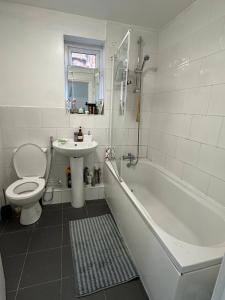 ein Badezimmer mit Badewanne, Toilette und Waschbecken in der Unterkunft Room for Rent Prime Location in Manchester