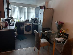 eine Küche mit Tisch und Kühlschrank in der Unterkunft Room for Rent Prime Location in Manchester
