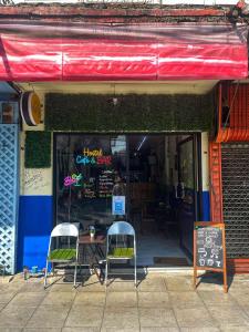 Un restaurante con dos sillas y una mesa en la ventana. en Happy Hope Khao San, en Bangkok
