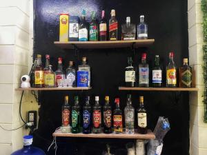 a wall with shelves filled with bottles of alcohol at Happy Hope Khao San in Bangkok +13 photos