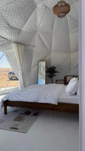 una camera da letto con un letto in una tenda di The mirage dome a Badīyah