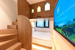 a small room with a bed and a large tv at QiuGuo Hotel Chao He Beijing Dashilan Xijie Qianmen Subway Station Branch in Beijing